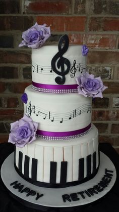 a three tiered cake decorated with music notes and purple flowers