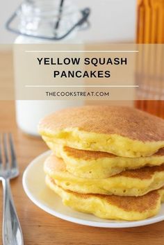 stack of yellow squash pancakes on a white plate with fork and glass in the background