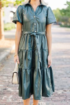 We can't think of a better midi dress for the fall season! That faux leather fabric and that rich hue are just what you are looking for! We also really love that button down design and it's flattering tied waist. Collared neckline Button down front closure Tied waist Short sleeves Faux leather fabric No stretch Payton is wearing the small. Fall Faux Leather Knee-length Dress, Faux Leather Knee-length Fall Dresses, Faux Leather Knee-length Dresses For Fall, Spring Faux Leather Belted Dress, Fall Belted Midi Dress For Casual Wear, Fall Midi Dress Belted For Casual Wear, Fall Midi Dress With Buttons For Date Night, Fall Midi Dress Belted For Dress Down Occasions, Chic Belted Faux Leather Dress