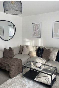 a living room filled with lots of furniture and pillows on top of a white rug