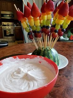 fruit skewers and dip in a bowl on a table