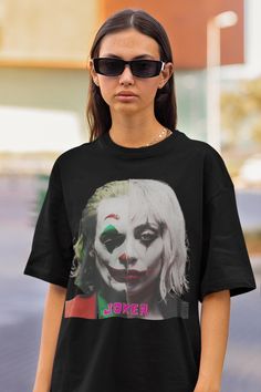 a woman wearing sunglasses and a black shirt with the image of joker printed on it