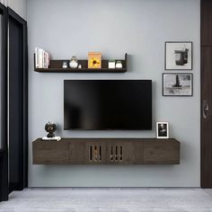 a flat screen tv sitting on top of a wooden shelf in front of a wall