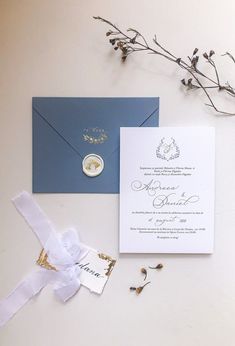 the wedding stationery is laid out on top of the white tablecloth and blue envelope