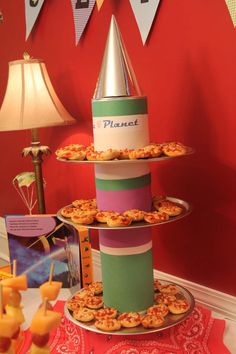 three tiered trays with food on top of each other in front of a red wall