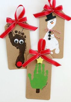 two tags with handprints and red ribbon tied to them, one has a snowman on it