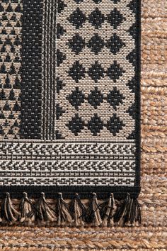 a black and white rug with tassels on it