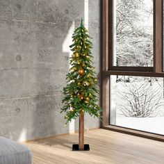 a small christmas tree sitting in front of a window