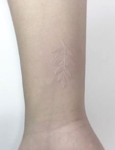 a small tattoo on the wrist of a woman's left arm, with leaves drawn on it