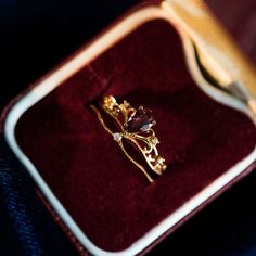 a gold ring sitting on top of a velvet case