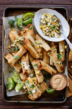 mexican food is served on a tray with dipping sauce and tortilla breadsticks