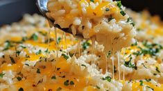 a spoon full of macaroni and cheese being scooped from the casserole