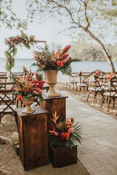 two vases filled with flowers sitting on top of wooden benches