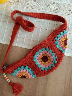 an orange crocheted purse sitting on top of a table