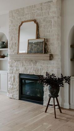 a living room with a fireplace, mirror and shelf on the wall above it's mantle