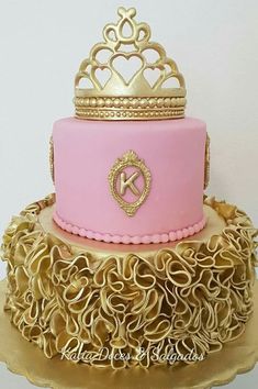 a pink and gold cake with a crown on top