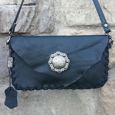 Nwt A Thick Black Leather, Small Crossbody Bag From Delila With A Stunning Antique Silver Medallion With Scrollwork. It Has A Rough Cut Flap With A Hidden Magnetic Closure. The Long Crossbody Strap Is Detachable And Drops 24.5". The Edges Are Trimmed With Black Suede Lacing And The Interior Is The Raw Suede With 3 Card Slots. It Measures 9" Wide, 5" In Height And Minimal Depth. A Wonderful Accent For Western Attire, A Boho Look Or Just A Great Contemporary Style. Detach The Strap And Use It As A Everyday Crossbody Clutch With Silver-tone Hardware, Silver Shoulder Clutch For Everyday Use, Silver Leather Clutch Shoulder Bag, Silver Clutch With Detachable Strap For Everyday Use, Leather Clutch With Silver-tone Hardware For Daily Use, Silver Leather Pouch Bag, Everyday Pouch Clutch With Silver-tone Hardware, Silver Leather Shoulder Bag With Mobile Phone Holder, Everyday Clutch With Silver-tone Hardware