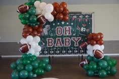 balloons are arranged in the shape of footballs on display at a sports themed baby shower