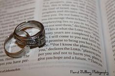 two wedding rings sitting on top of an open book