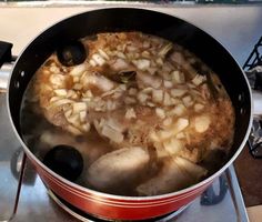 a pot filled with food sitting on top of a stove next to a burner