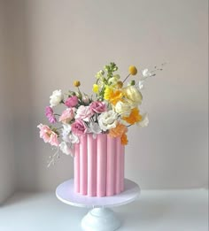 a pink and white cake with flowers in it