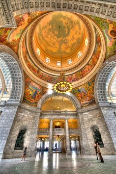 two people are standing in the middle of an ornate building with painted ceilings and arches