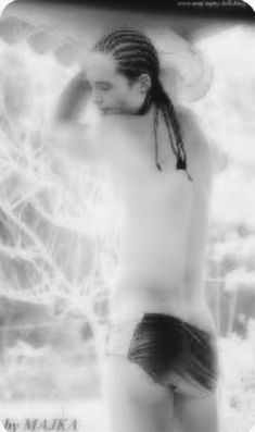 black and white photograph of a man with dreadlocks on his head wearing a swimsuit