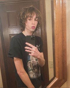 a young man taking a selfie in front of a mirror with an elephant t - shirt on