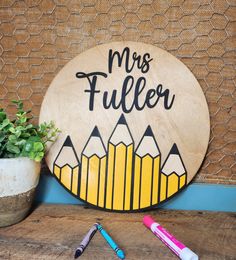 a wooden sign that says mrs tuller with pencils next to it