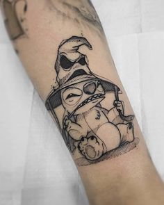 a person with a tattoo on their arm that has a drawing of a cartoon character