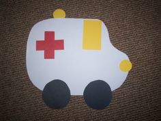 a paper cut out of a car with a red cross on it's side