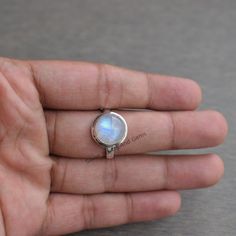 Gemstone-Rainbow Moonstone Shape-Round Stone Size - 10 MM Metal-925 Sterling Silver This One of a kind ring is adorned with beautiful rich Rainbow Moonstone Gemstone set in sterling silver band. About gemstone- Rainbow moonstone is associated with various Moon Goddesses .Moonstone has a very strong connection to the spiritual world. It has great nurturing energy which will give ease and guide in difficult times especially in issues related to love and family. It helps in banishing our own negati Moonstone Rings With Moon Phase Design, Moon Phase Moonstone Rings, Sterling Silver Round Moonstone Ring With Moon Phase, Natural Stone Stackable Rings, Silver Stackable Rings With Natural Stones, Sterling Silver Stackable Rings With Natural Stones, Moonstone Rings With Bezel Setting, Silver Opal Ring For Healing, Sterling Silver Moonstone Ring With Natural Stones