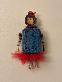 a doll is hanging on the wall with a tin can