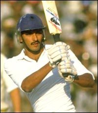 a man holding a baseball bat while wearing a blue helmet and white shirt with the number 25 on it