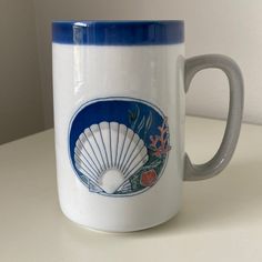 a white and blue coffee mug sitting on top of a table