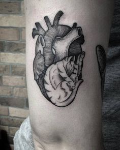 a black and white heart tattoo with a cat on the inside of it's arm