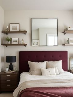 a bedroom with a bed, mirror and shelfs on the wall above it's headboard