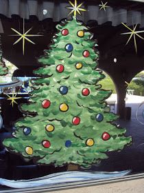 a decorated christmas tree sitting inside of a window