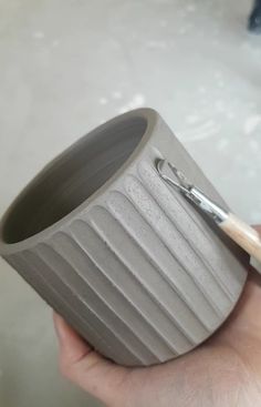 a person holding a cup with a brush in it