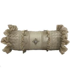 a decorative pillow with ruffles and beads on the edges is shown against a white background