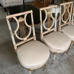 four chairs and a table in a room with carpeted flooring on the ground