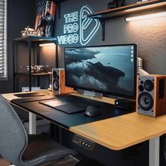 a desk with a computer and speakers on it in front of a window that reads the pro video