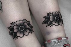 two people with matching tattoos on their legs, both wearing socks and one has a flower tattoo on her left leg