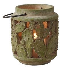 a small cactus planter with a candle in it's center and a black handle