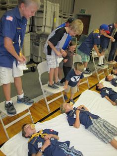 a group of people standing and laying on top of beds in a room with bunk beds