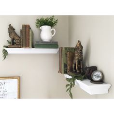 two white shelves with books and figurines on them, one holding an alarm clock