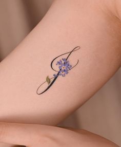 a woman's arm with a tattoo on it and a flower in the middle