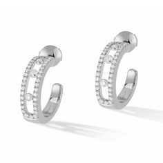 Pared down style and modern, these white gold pave diamond hoop earrings are the best everyday companions of a woman for a glamorous and stylish look. Diamond jewels of the Move Joaillerie collection, these diamond jewels are recognizable by the diamonds in motion. Three luminous stones on each ear, perfect symbols of the love of yesterday, today and tomorrow. In this aerial pave version, these 18k white gold diamond hoop earrings will wrap up the face with a special glow. Diamonds are 1/2ctw, G in color, and VS in clarity. Earrings measure 15mm in diameter. Messika Style #: 04993-WG White Gold Hoop Earrings, Gold Diamond Hoop Earrings, White Gold Diamond Earrings, Luxury Jewelry Brands, White Gold Hoops, Classic Bracelets, Mini Hoop Earrings, Gold Diamond Earrings, Diamond Hoop Earrings