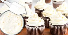 chocolate cupcakes with white frosting on a wooden tray