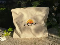 a white bag sitting on top of a cement ground next to a plant and flower